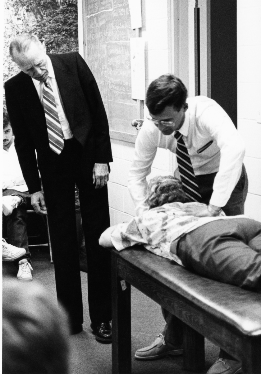 Visiting professor Larry Jones looks on as a student performs osteopathic manipulative therapy