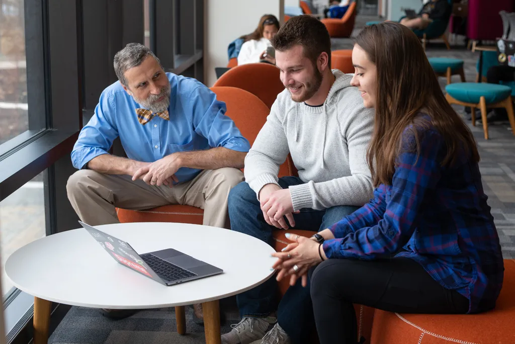 a faculty member sits with two students