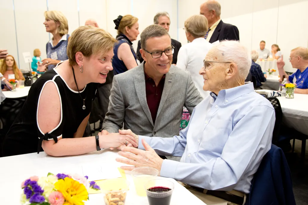 UNE President James Herbert and first lady Lynn Brandsma visit with Beaudry at the Maine Basketball Hall of Fame Induction reception.