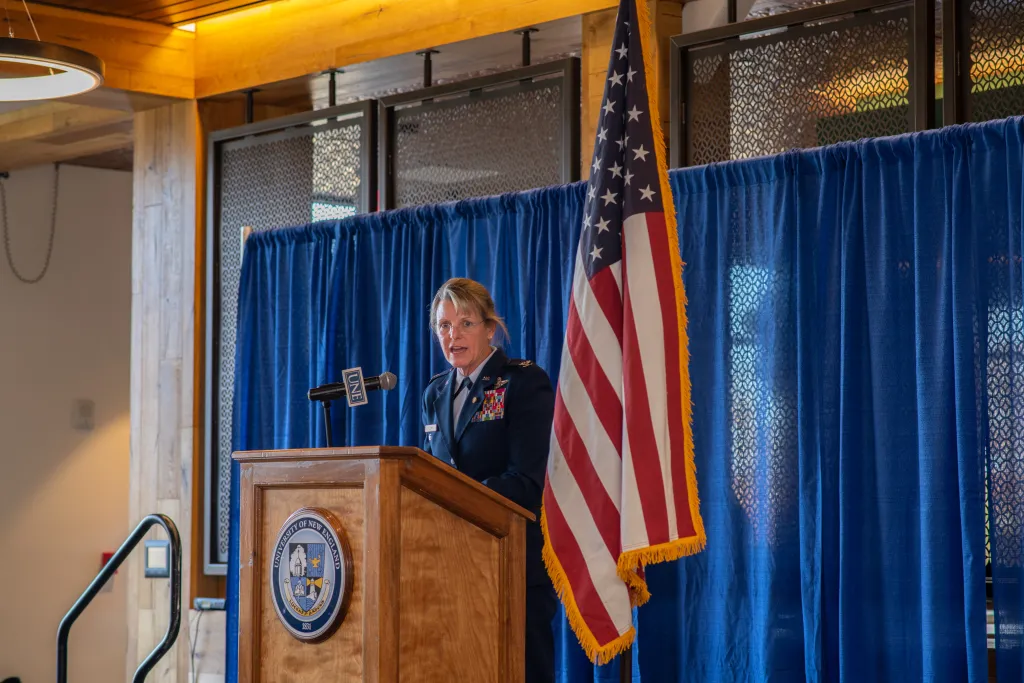Retired Air Force Col. Jennifer Fullmer stands at the podium