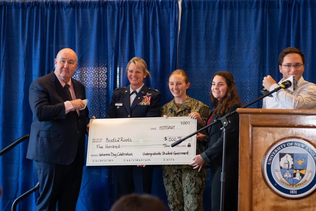 The Undergraduate Student Government presents a $500 check to Boots2Roots