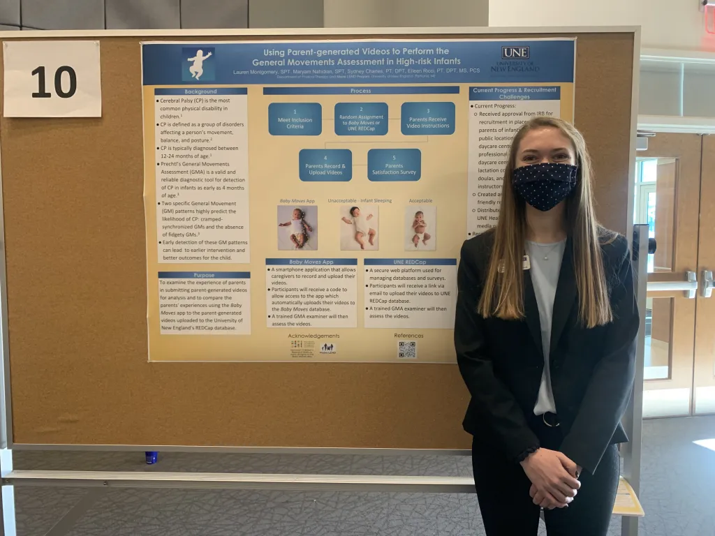 Female student poses in front of poster