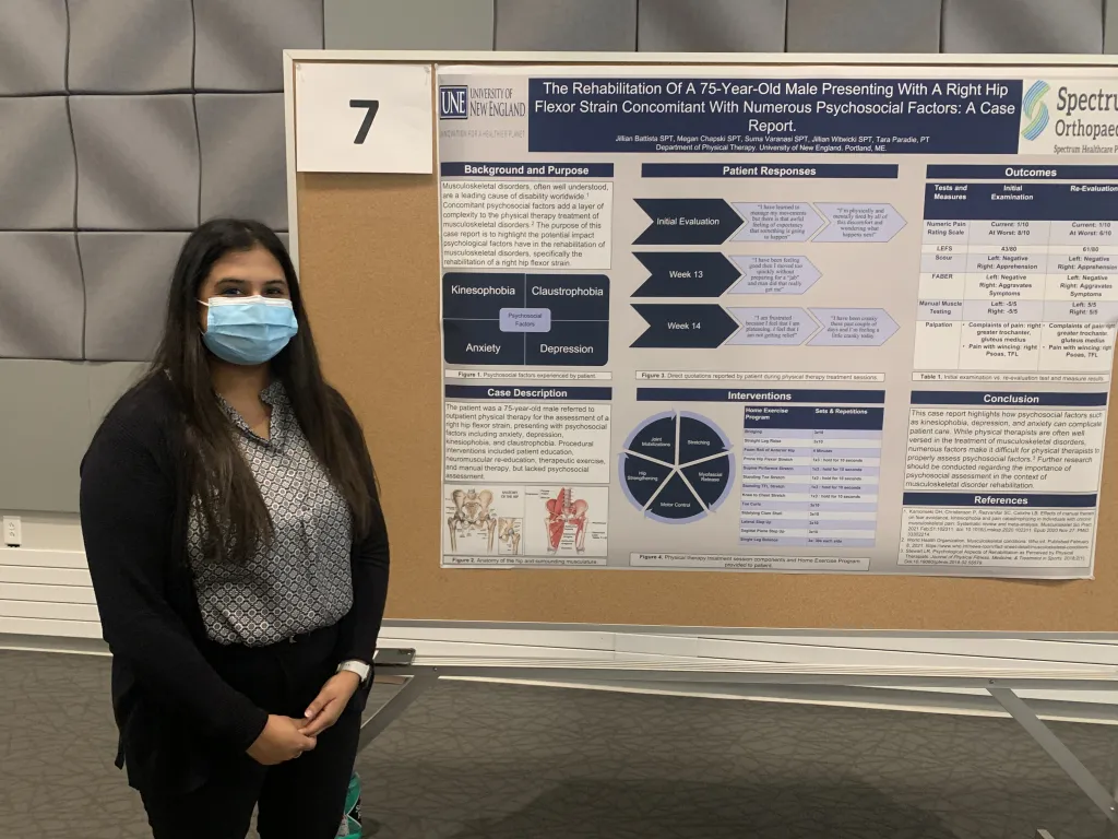 Female student poses in front of poster