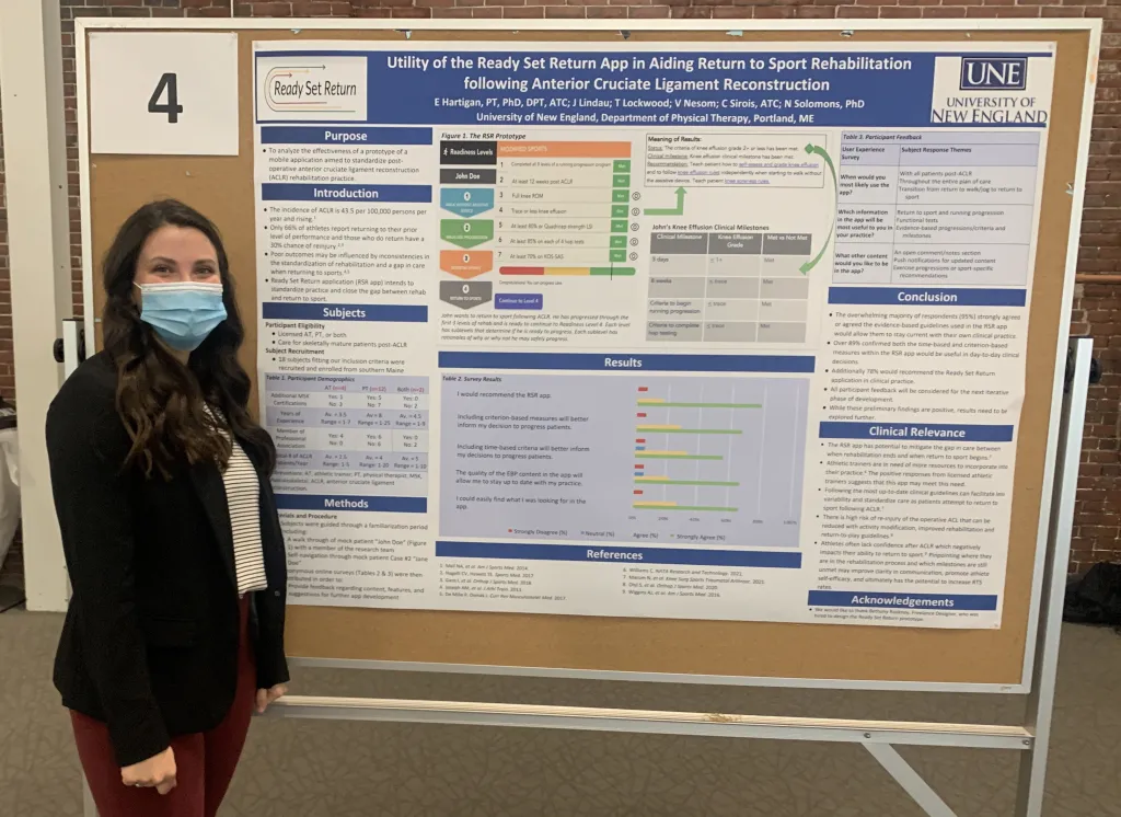 Female student poses in front of poster