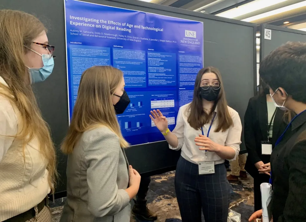 Aubrey Sahouria presents a poster to a group of people at the EPA conference