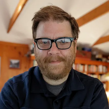 Photo of man in glasses smiling for portrait