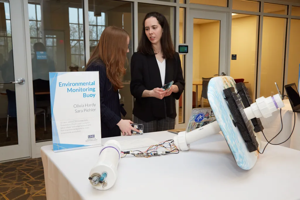 Sara Piehler and Olivia Hardy with their automatic water quality monitoring buoy