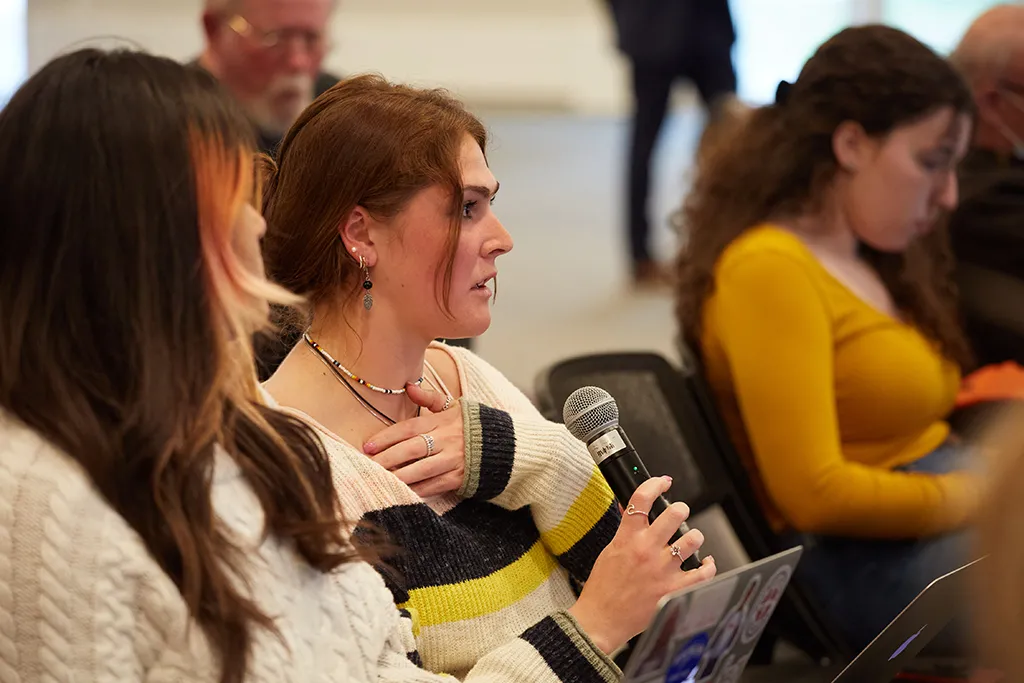 A student asks a question at a lecture