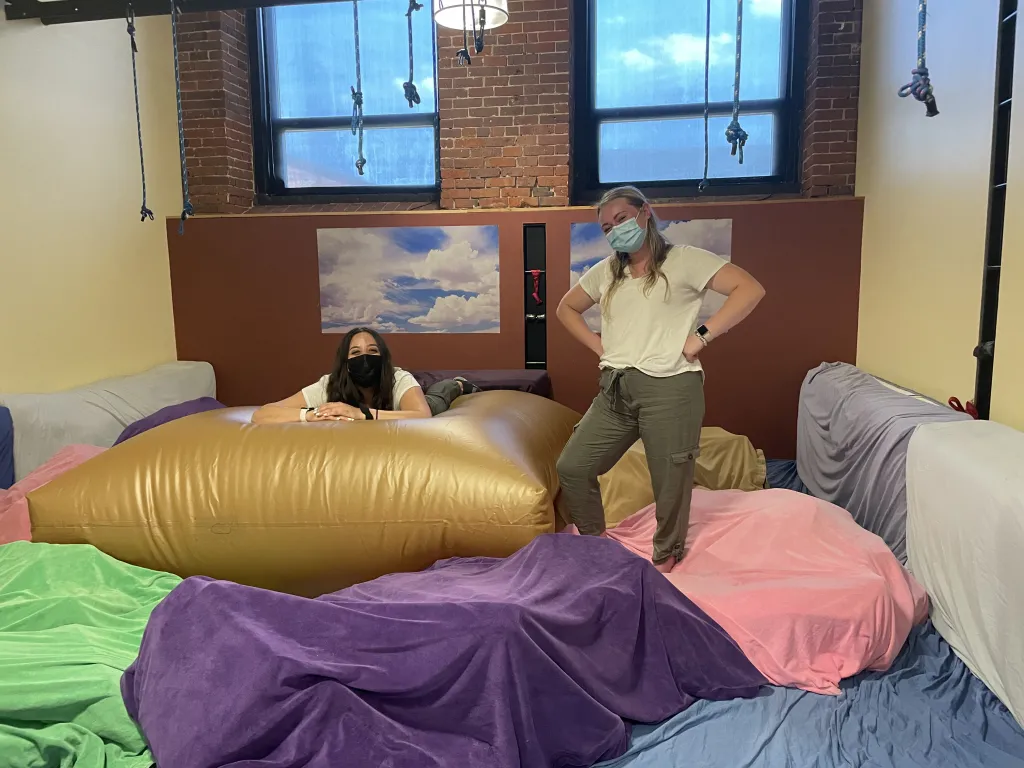 Students pose on large blow-up mats at the center