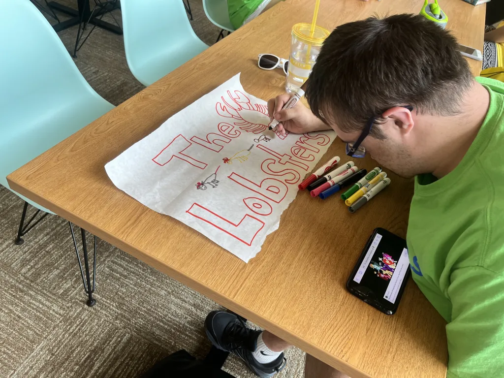 A PALS Partner makes a sign for his team