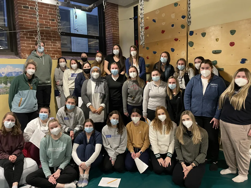 A group of students and faculty pose for a photo at the OTA-Koomar Center 