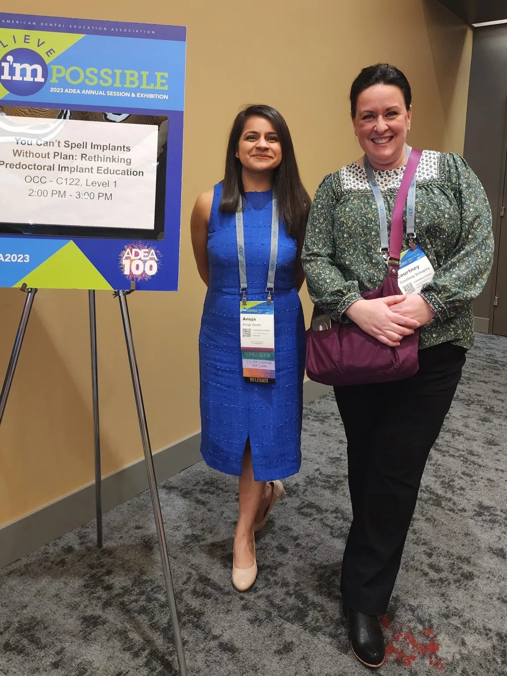 A student and faculty member pose in front of a research poster