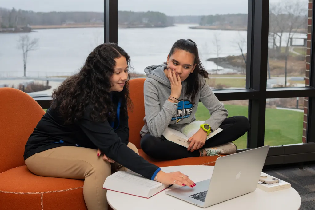 Two U N E students study together in the Ripich Commons