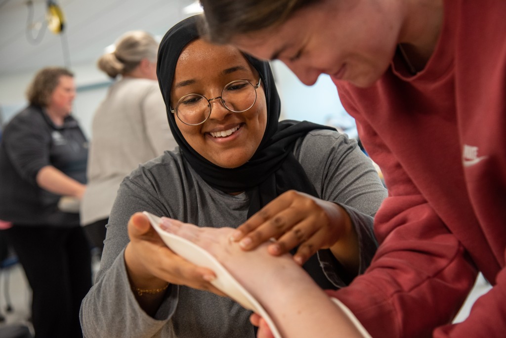 An Occupational Studies student practices applying a splint on a classmate's wrist