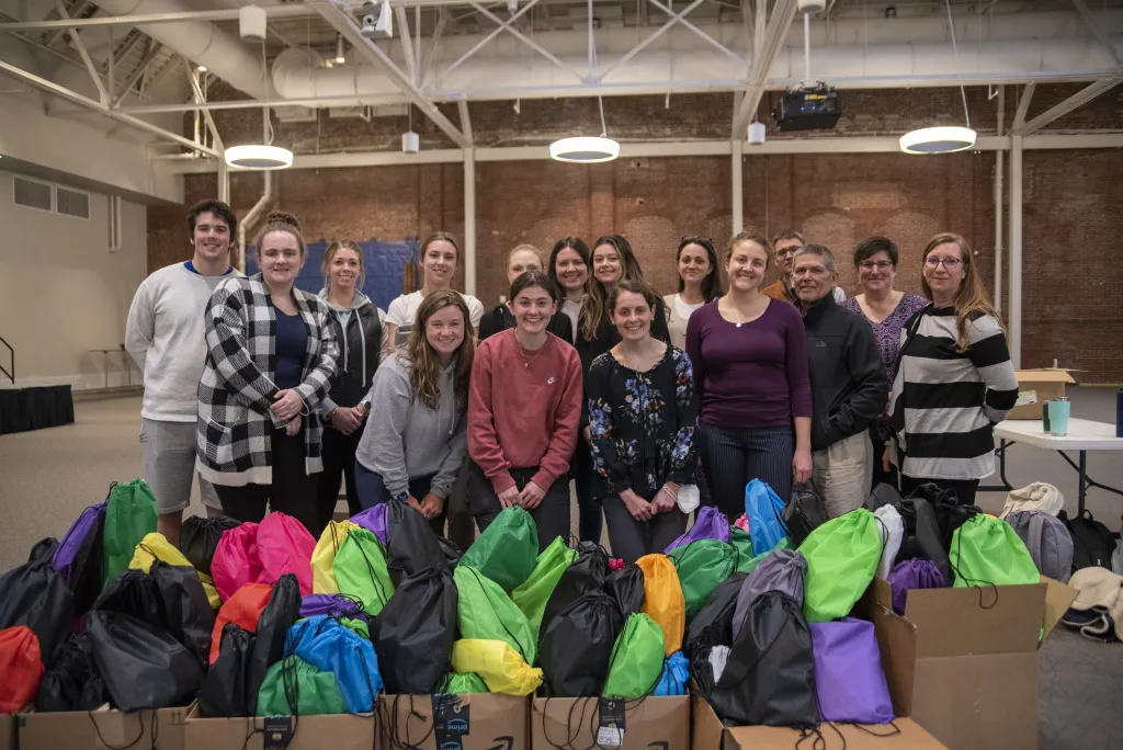 A group of students pose together for a Service-Learning program where they prepared harm-reduction bags for the Maine Correctional Facility