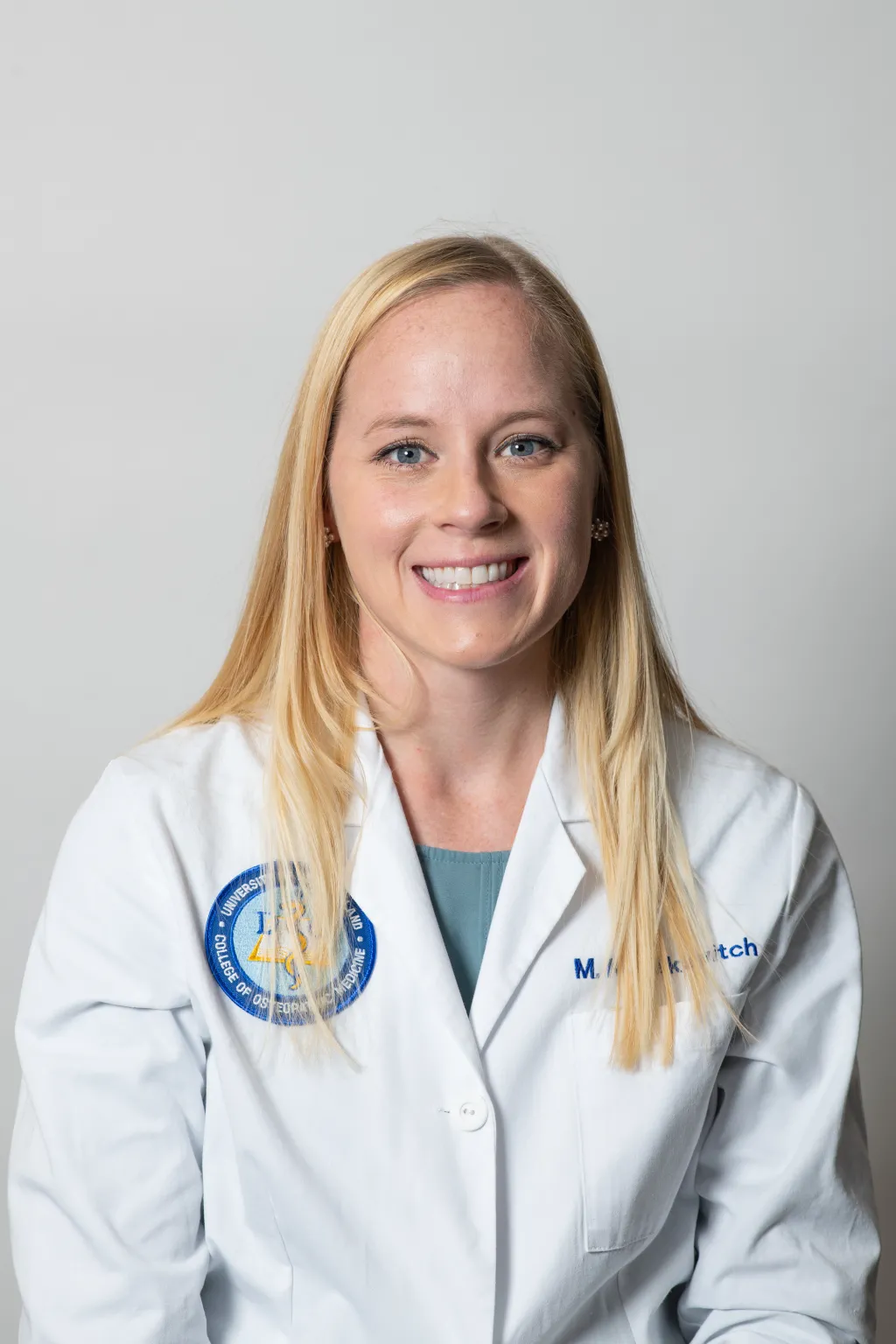 Portrait of Melanie Kusakavitch wearing COM white coat