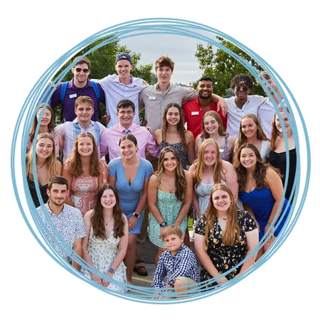 A large group of undergraduate U N E students pose together and smile
