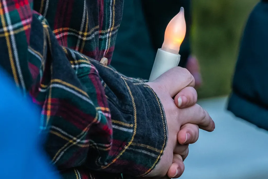 A student holds a battery-operated candle lap