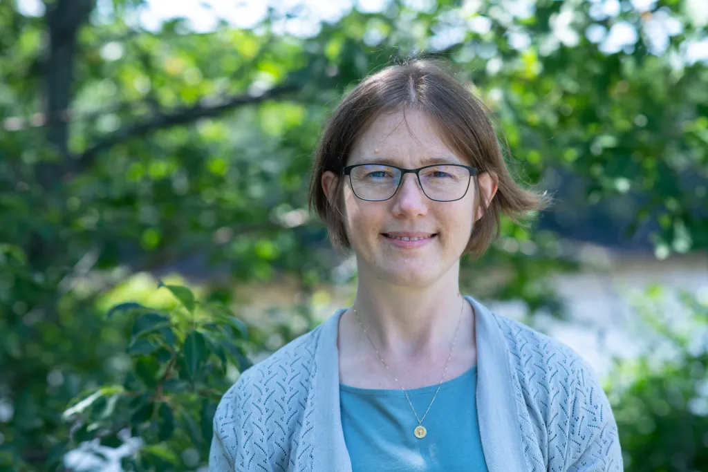 Portrait of Kathleen Becker against trees