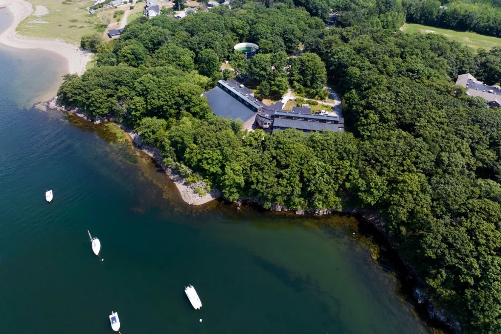 An aerial view the ocean next to a college campus