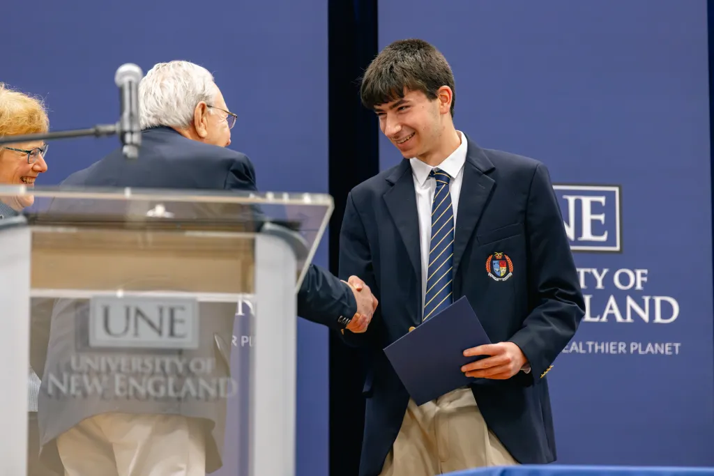 Faculty shakes hand with a student at University Award Ceremony