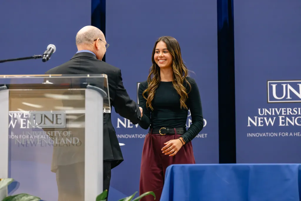 Faculty member shakes hand with a student at University Award Ceremony