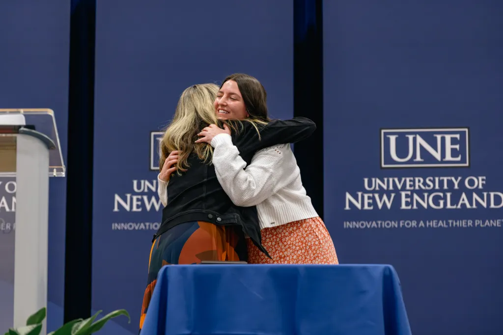 Faculty hugs a student at University Award Ceremony