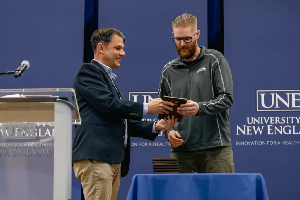 Charles Tilberg shakes hand with a student at University Award Ceremony