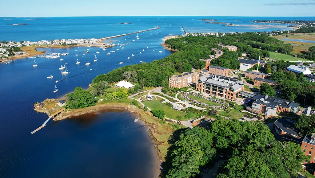 an aerial view of U N E's Biddeford campus including buildings, the beach, and the ocean