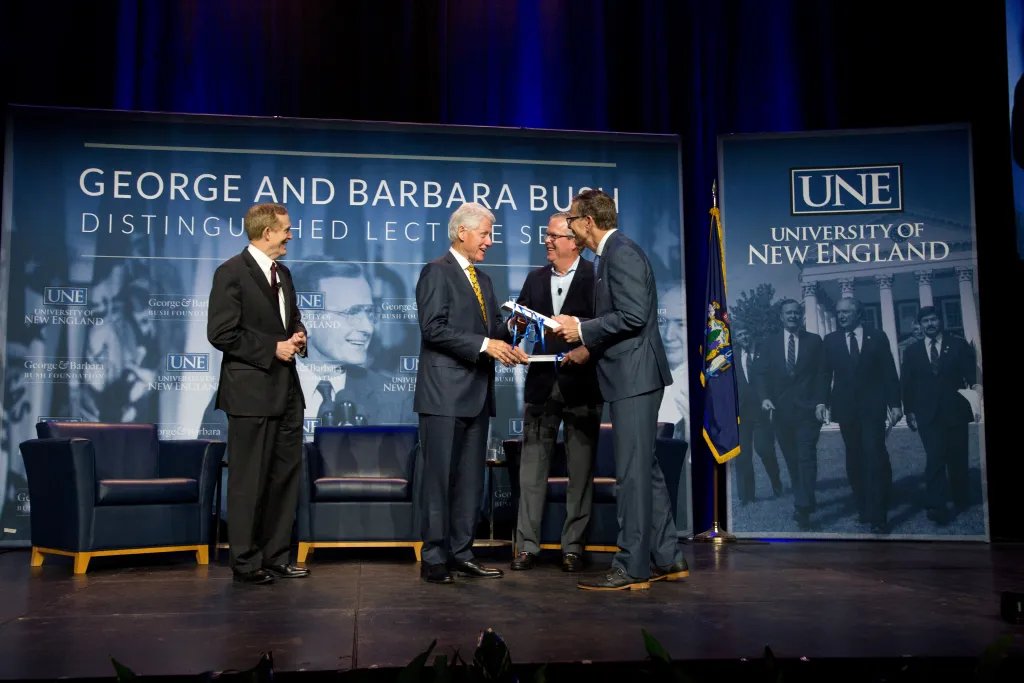 UNE President James Herbert thanks the distinguished Bush Lecture guests with a token of appreciation: UNE-branded socks designe