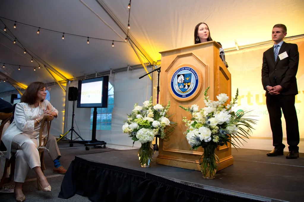 President Ripich looks on as student speakers Chelsea Toussaint and Ian Corbett take the stage.