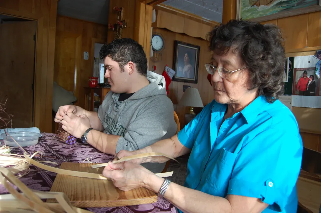 Molly Neptune Parker creating hand baskets with her grandson