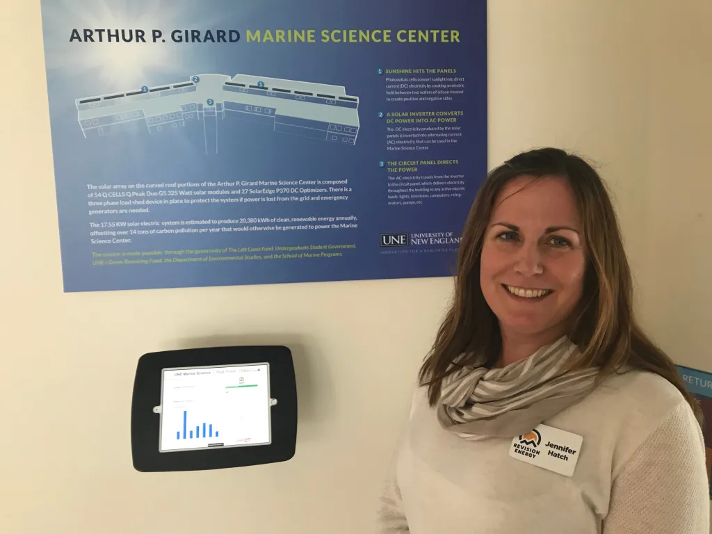 Jennifer Hatch of ReVision Energy stands in front of the monitor that shows how much power the panels are generating
