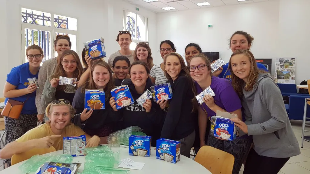 A pleasantly surprised group of students pose with the loot that President Herbert sent them upon his return to the U.S.