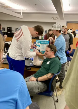 Kyle Scully is given a fake splint by students.