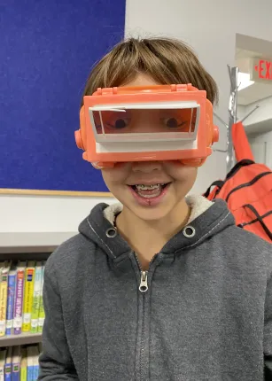 A boy wears vision-shifting goggles at Maine Bioscience Day