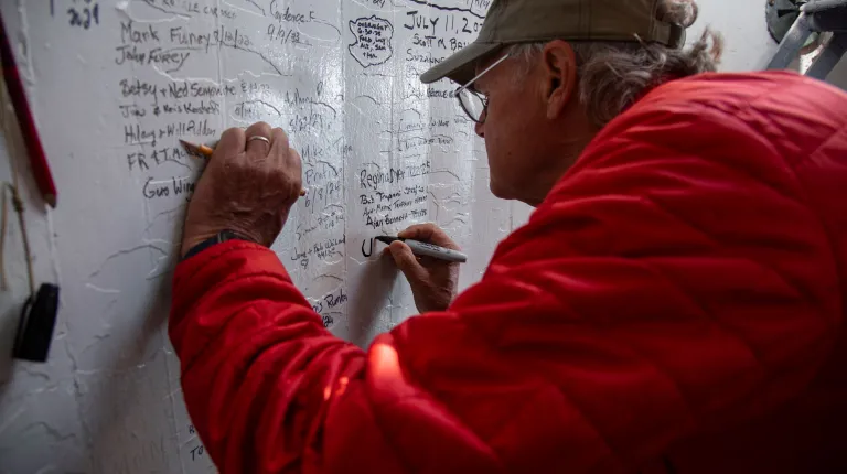 Reiche signs the wall inside the lighthouse