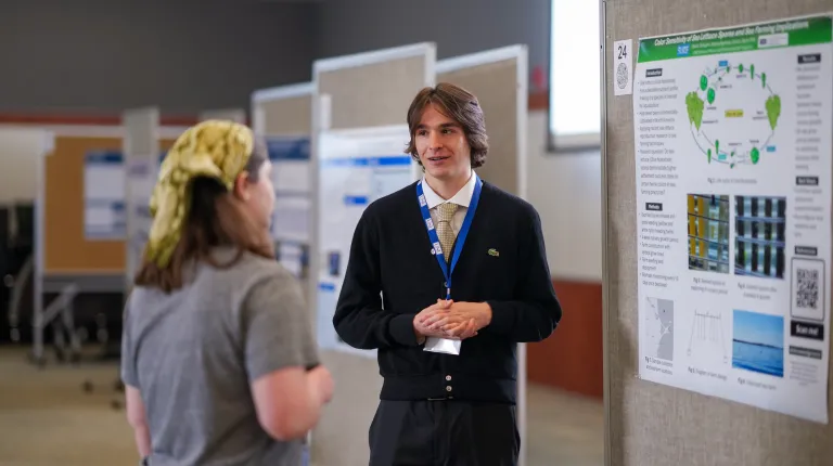 student presents research to other student at SURE research symposium