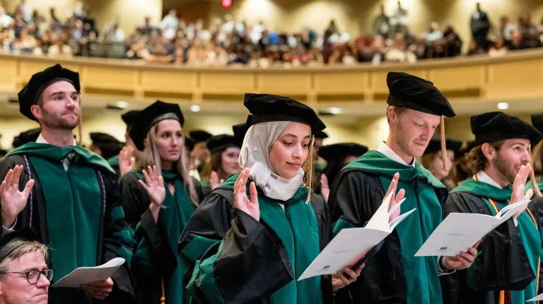 UNE medical students take the Osteopathic Oath after receiving their doctoral hoods