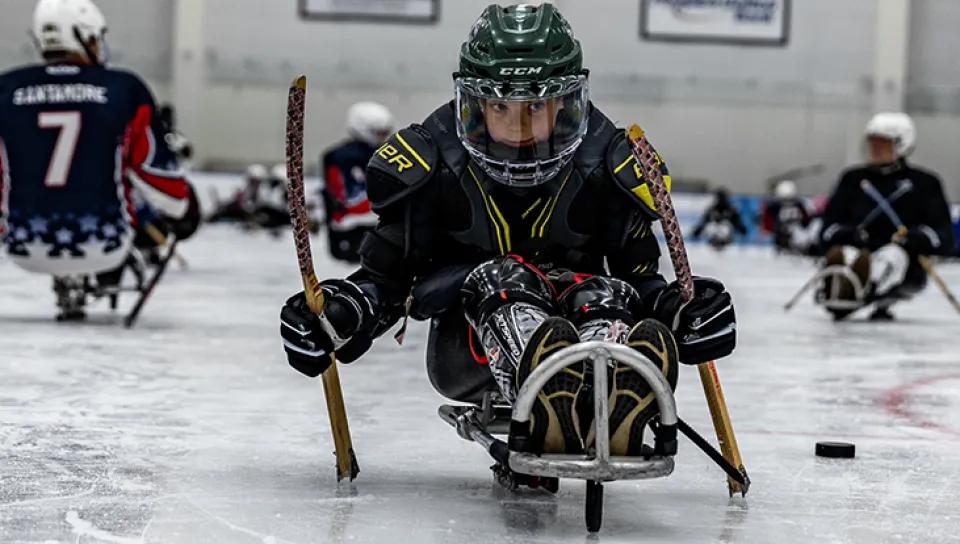 A child uses an adaptive hockey sled