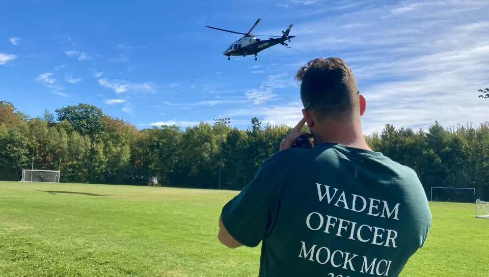 A UNE student watches LifeFlight takeoff.