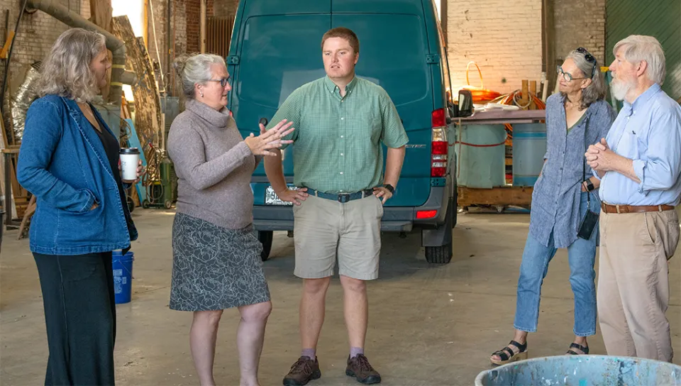 Delilah Poupore, Heart of Biddeford; Alethea Cariddi, UNE; Will Kotchtitzky, UNE; and Michele Polacsek, UNE speak to a community member inside a building in Biddeford.