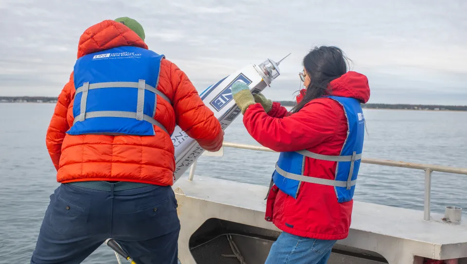 UNE student Jasmin Townsend-Ng (’26) assists Dr. Kochtitzky in lower a buoy