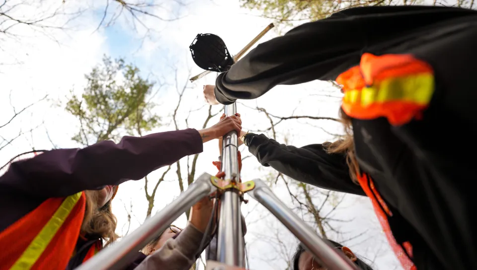 Students place the final components of a forest weather station