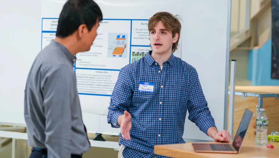 Student Tyler Janik speaks with a showcase attendee