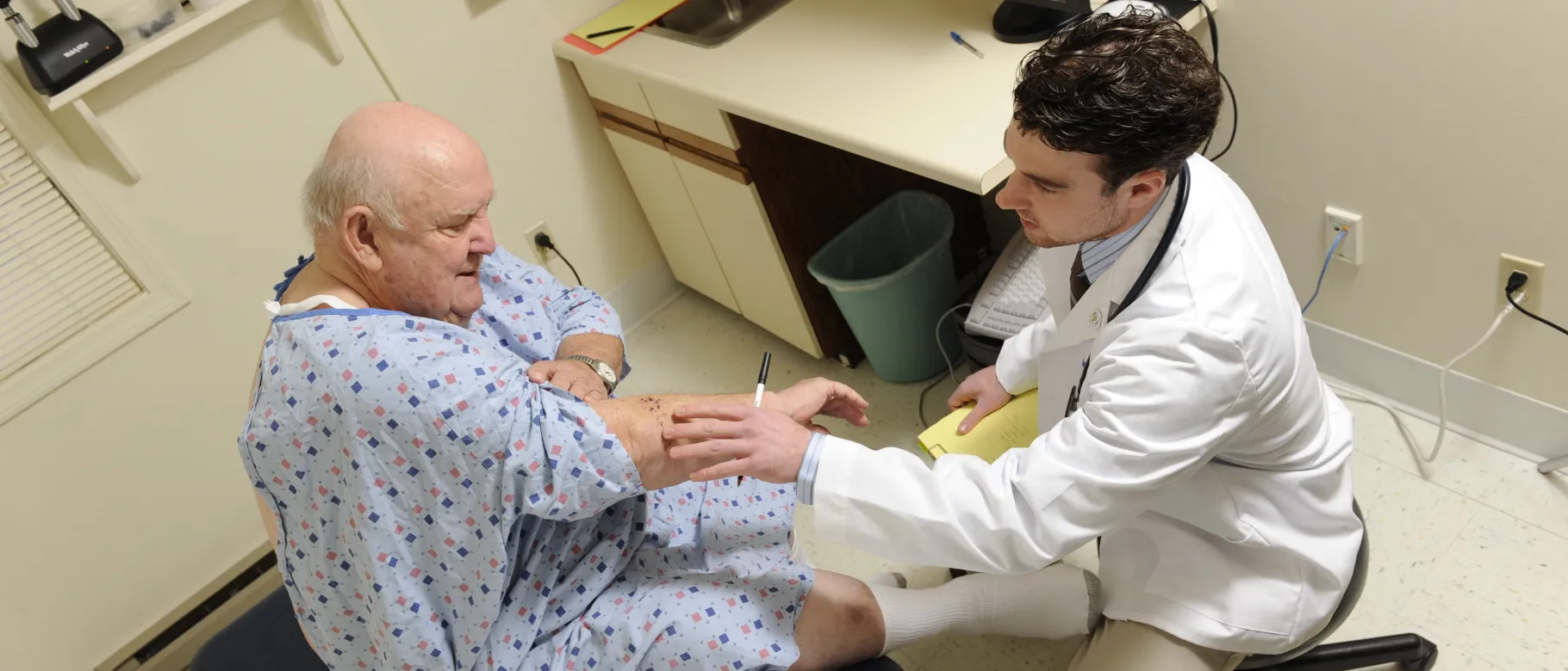 A UNE student treats an elderly patient