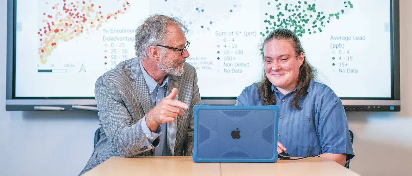 Ruth Ellis (Environmental Science, ’25) and Cameron Wake, Ph.D.discuss pollution data visualizations including maps showing disadvantaged populations and PFAS levels across Maine.