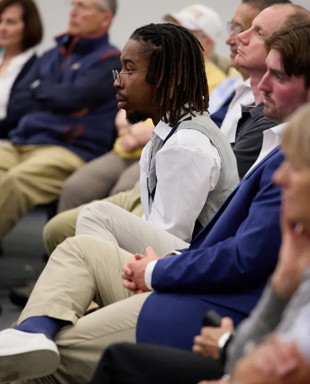 UNE students watch a panel discussion in the Harold Alfond Forum