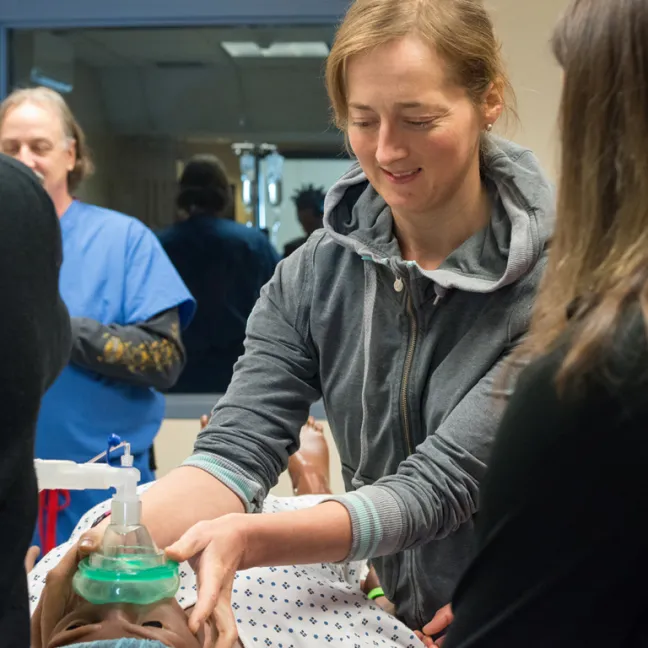 A student administers anesthesia to a simulation dummy