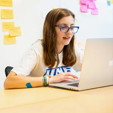 A student sits working on a lap top
